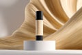 Elegant foundation bottle standing on a minimalist white pedestal with flowing golden beige fabric backdrop highlighting smooth Royalty Free Stock Photo