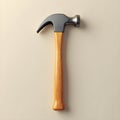 Sleek hammer with a wooden handle and metal head rests on a plain, cream colored surface Royalty Free Stock Photo