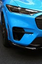 Sleek headlight of modern electric compact crosover SUV car Ford Mustang Mach-E in light blue color