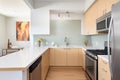 sleek kitchen with stainless steel appliances and asymmetrical cabinetry