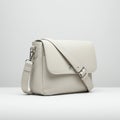 A sleek, light gray shoulder bag featuring a smooth leather texture. It has a broad flap Royalty Free Stock Photo