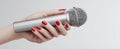 The sleek microphone held elegantly in a perfectly manicured hand..AI generated image Royalty Free Stock Photo
