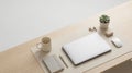 angled top view of closed laptop on desk mat with linen notebook, wireless mouse, and earbuds Royalty Free Stock Photo