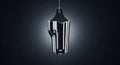 A sleek modern 3D rendered metallic bottle or vase object hanging from a string against a solid black background with a shiny Royalty Free Stock Photo