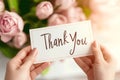 Thank you card in hands with tulip bouquet on blurred background Royalty Free Stock Photo