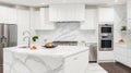 A sleek modern kitchen with white cabinets and white marble countertops with stainless steel appliances Royalty Free Stock Photo