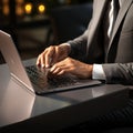 A sleek and modern laptop, with a metallic finish and a backlit keyboard. Hand of businessman on keyboard, business professionals