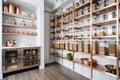 a sleek and modern pantry with glass jar storage, steel bins, and copper accents