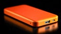 Sleek modern portable external storage device in bright orange with usb and Type-C ports resting on reflective black surface for Royalty Free Stock Photo