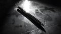 sleek pen resting on reflective surface, capturing light beautifully. contrast of shadows and highlights creates dramatic effect, Royalty Free Stock Photo