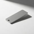 A sleek rectangular metal object with beveled edges is placed on a white surface. It has a brushed Royalty Free Stock Photo