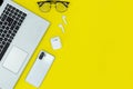 Modern Tech Workspace With Laptop, Smartphone, AirPods And Plant On Bright Yellow Background.Ideal for tech, work, and lifestyle t Royalty Free Stock Photo