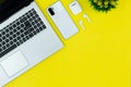 Modern Tech Workspace With Laptop, Smartphone, AirPods And Plant On Bright Yellow Background.Ideal for tech, work, and lifestyle t Royalty Free Stock Photo
