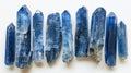 Sleek and slender Kyanite blades exhibiting their sapphire-like blue elegance, arranged gracefully on a white canvas