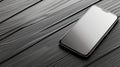 A sleek smartphone displayed on a textured wooden surface, showcasing modern design and technology in a minimalistic setting Royalty Free Stock Photo