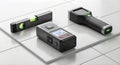 Three essential surveying tools: laser measure, spirit level, and stud finder arranged on white tiles Royalty Free Stock Photo