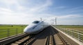 Sleek white bullet train speeding on elevated railway through green fields Royalty Free Stock Photo