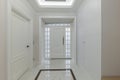 Sleek White Corridor: Stylish Mirror and Wardrobe with Elegant White Doors