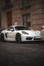 Sleek, white Porsche sports car is parked on a city street