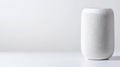 sleek white smart speaker with a mesh exterior sits on a simple white surface against a plain, light background. Royalty Free Stock Photo