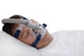 Sleep apnea therapy, Man sleeping in bed wearing CPAP mask.