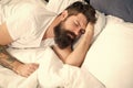 Sleep disorders concept. Man bearded hipster having problems with sleep. Guy lying in bed try to relax and fall asleep