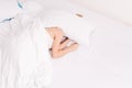 A young girl is too lazy to get out of bed, woman covers her face with a pillow.Sleep, early morning, waking up, too lazy to get Royalty Free Stock Photo