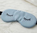 Sleep mask with closed eyes on a soft light background. Royalty Free Stock Photo