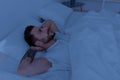 Sleep problems, insomnia and bad thoughts. Young thoughtful man lying in bed, looking at ceiling and thinking Royalty Free Stock Photo