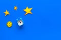 Sleep time, clock on the bed concept. Alarm clock near moon and stars cutout on blue background top view copy space