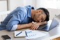 Sleep At Work. Exhausted overworked man employee napping at workplace in office Royalty Free Stock Photo