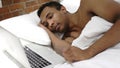 Sleeping African Man Near Laptop in Bed for Rest Royalty Free Stock Photo