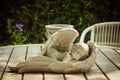 Sleeping angel cupid statue on wood table and chair in the garden, vintage photo