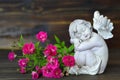 Sleeping angel and roses on wooden background Royalty Free Stock Photo