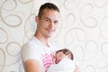 Sleeping baby in the arms of his father. Portrait of a young father holding his newborn baby son at home Royalty Free Stock Photo