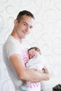 Sleeping baby in the arms of his father. Portrait of a young father holding his newborn baby son at home Royalty Free Stock Photo