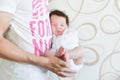 Sleeping baby in the arms of his father. Portrait of a young father holding his newborn baby son at home Royalty Free Stock Photo