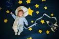 Sleeping baby boy astronaut on a background of the sky