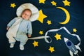 Sleeping baby boy Caucasian appearance on starry space background with rocket