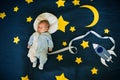 Sleeping baby boy Caucasian appearance on starry space background with rocket