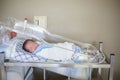 Happy newborn baby boy sleeping in a hospital room bed Royalty Free Stock Photo