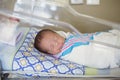 Happy newborn baby boy sleeping in a hospital room bed Royalty Free Stock Photo