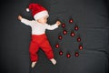 Sleeping baby boy with Santa hat lying with Christmas balls Royalty Free Stock Photo