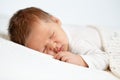 Sleeping Baby. Close up Newborn Face Portrait with long Hair. One month Boy sleep on Stomach under White Blanket. Infant Health Royalty Free Stock Photo