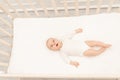 Sleeping baby and his toy in white crib. Nursery interior and bedding for kids. Cute little boy napping in bassinet. Kid taking a