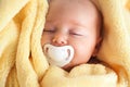 Sleeping Baby With Pacifier In A Yellow Blanket Royalty Free Stock Photo