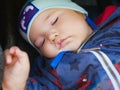 Sleeping baby in a stroller for a walk. close-up. Cute little boy sleeping outdoors Royalty Free Stock Photo