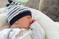 Sleeping baby in swing automatic electrical chair and sucking left thumb Royalty Free Stock Photo