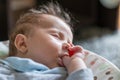 Sleeping baby in swing automatic electrical chair and sucking left thumb Royalty Free Stock Photo