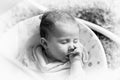 Sleeping baby in swing automatic electrical chair and sucking left thumb Royalty Free Stock Photo